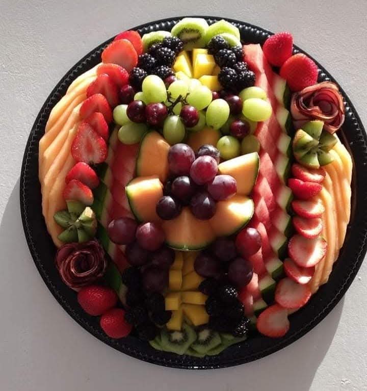 Decorated fresh fruit platter with berries, melon and grapes