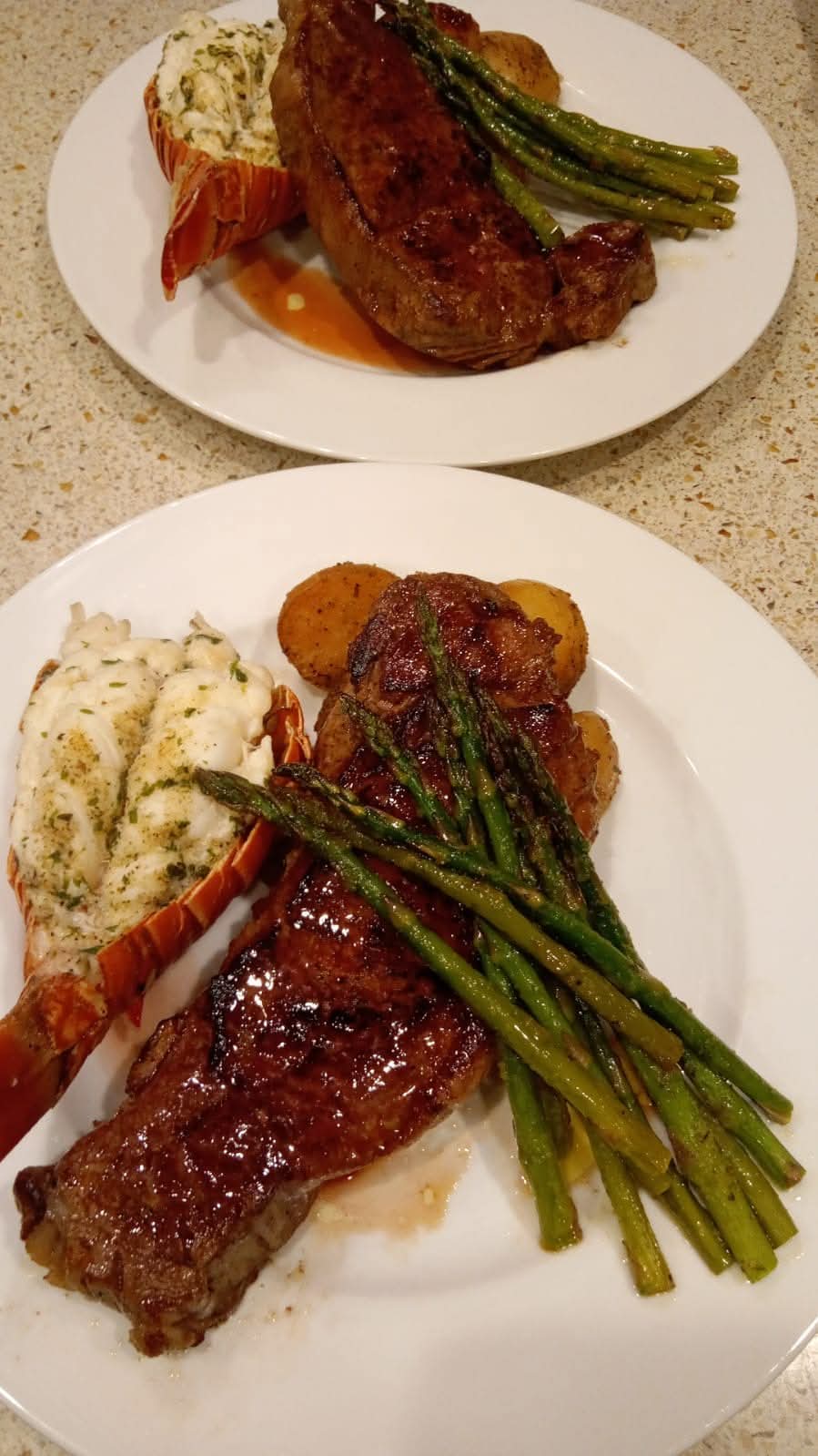 Plated steak with buttered lobster tail, potatoes and asparagus