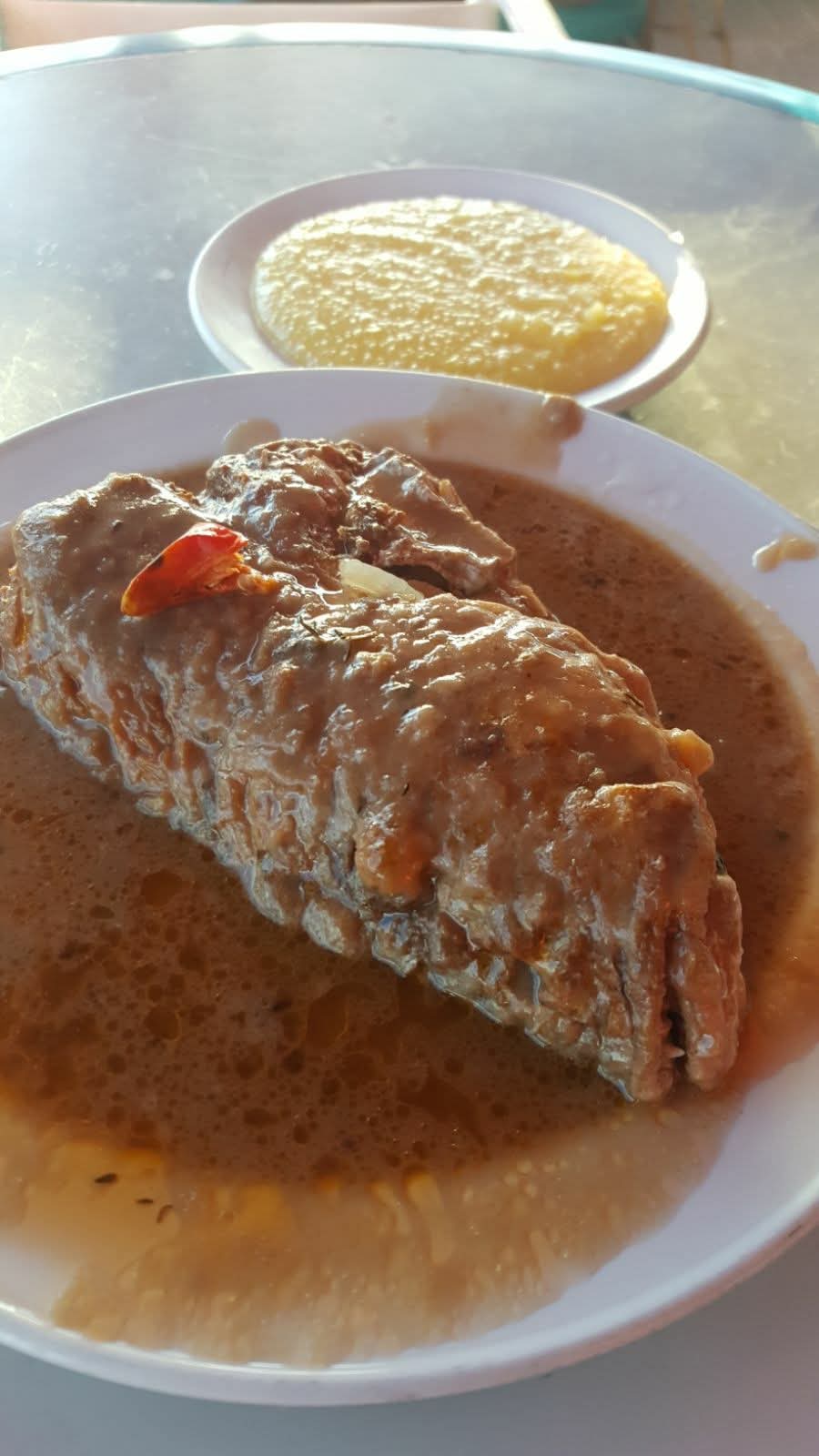 Bahamian stew fish in rich gravy served with grits